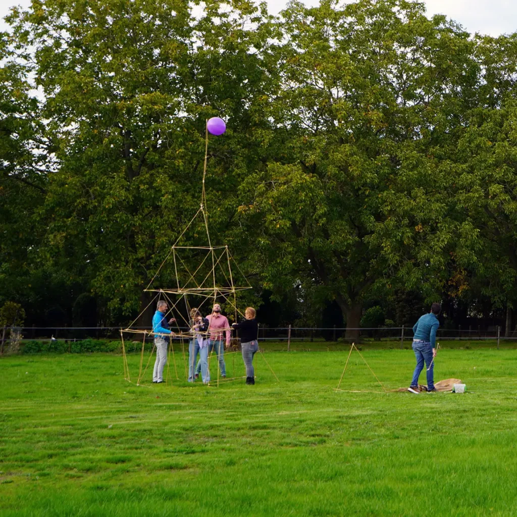 Samenwerking en focus tijdens een workshop bouwen met bamboestokken voor groepen.