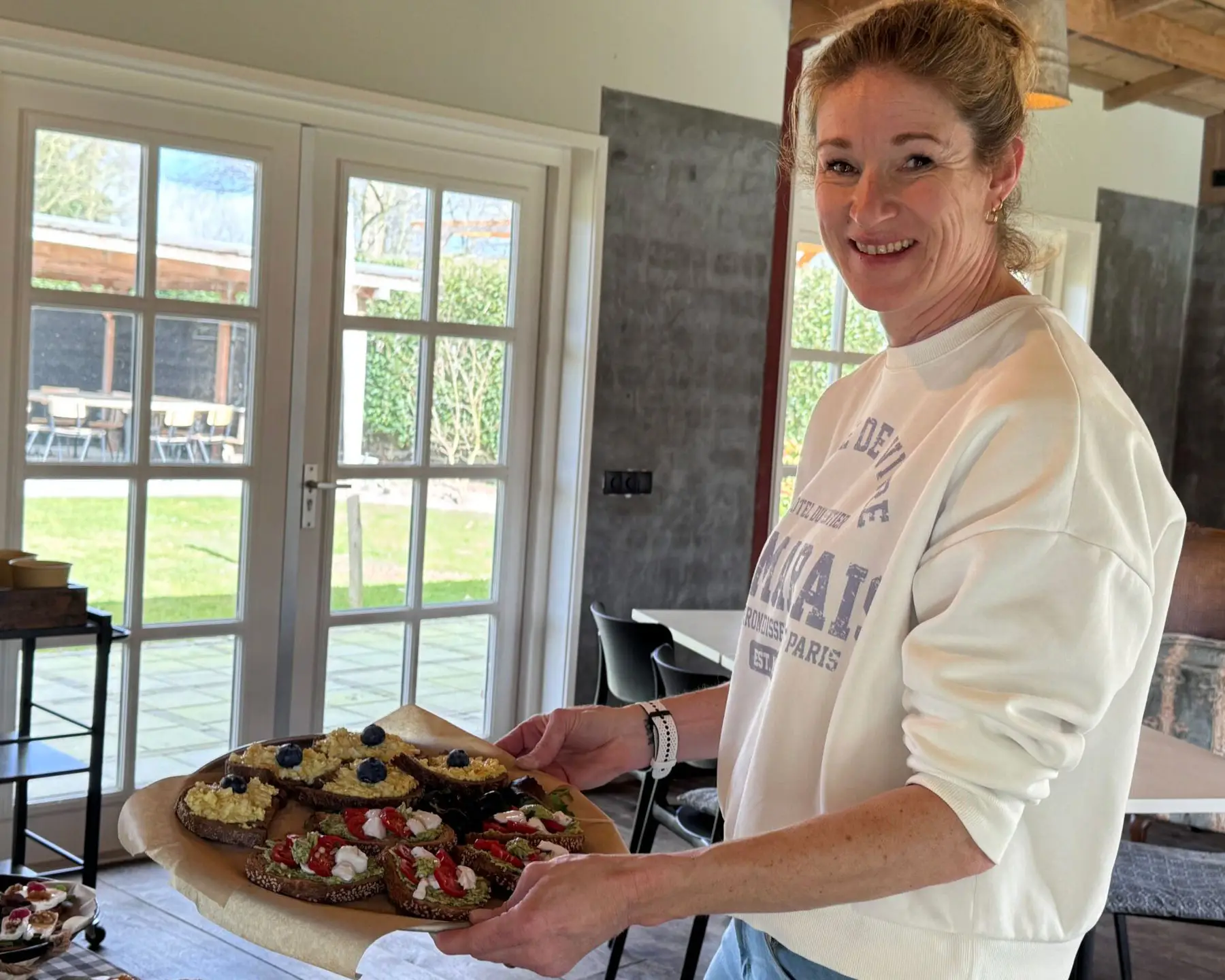 Gastvrouw Marieke bereidt verse catering voor een bijeenkomst bij De Vergaderij.