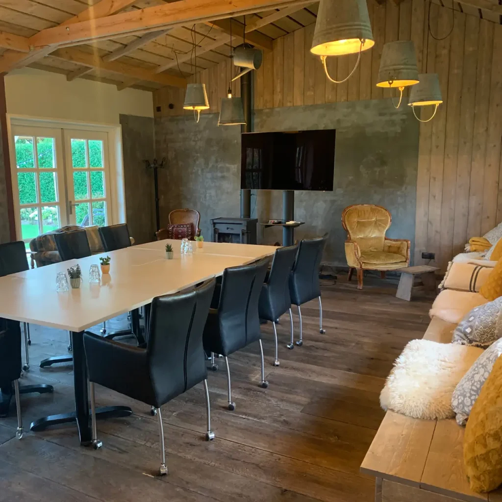 Uitzicht vanuit het Tuinhuis op de omliggende groene tuin van de vergaderlocatie.